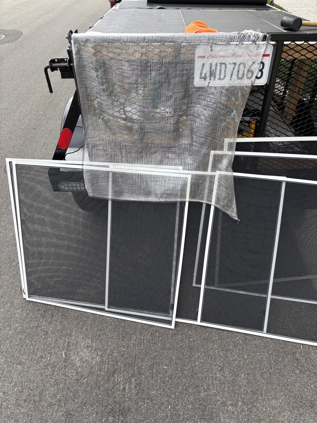 Worn-out mesh removed from old screens next to a set of new screens