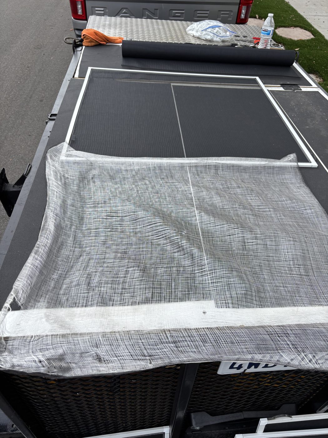 Old torn mesh being replaced on the mobile screen repair table